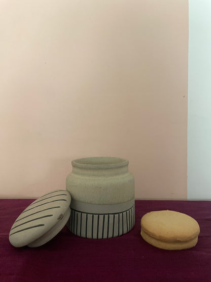 Medium ceramic jar with lid featuring black stripes, bottom half in grey with black stripes, cookies placed beside. Shop kitchenware Bangalore.