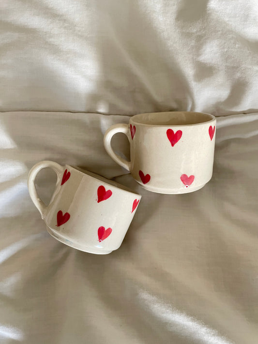 small off white glaze tea/coffee cups with handle &  with tiny red hearts painted all over the mug. microwave & dishwasher safe. perfect for daily use 