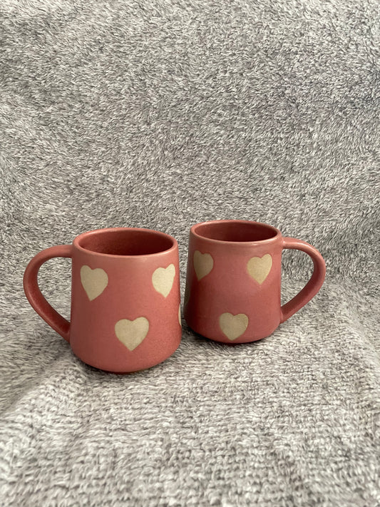 tall onion pink ceramic mug with handle adorned with stone ware finish heart motifs all over. microwave & dishwasher safe. perfect for daily use