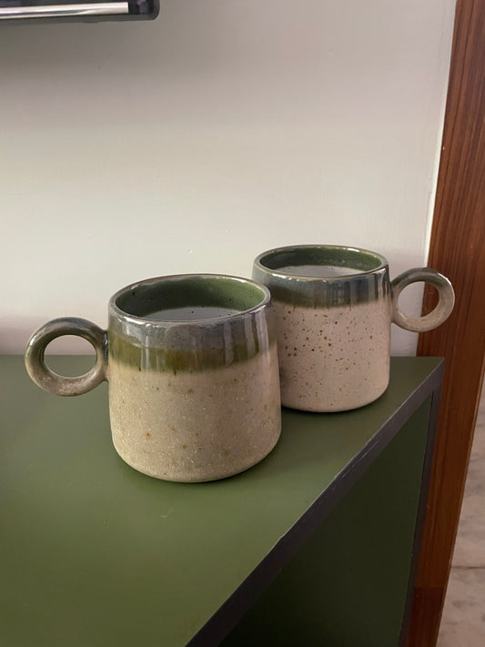 A more rounded ceramic mug with a cute round handle, a dual glaze finish of green & beige earthy tones, microwave & dishwasher safe, ideal for daily use